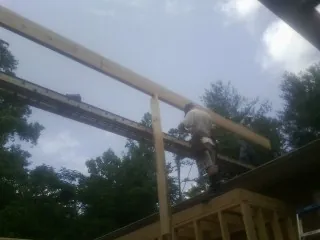 Carpenter setting a ridge beam over a new addition frame — Ice Dam Removal by Roofing Brothers in Paterson