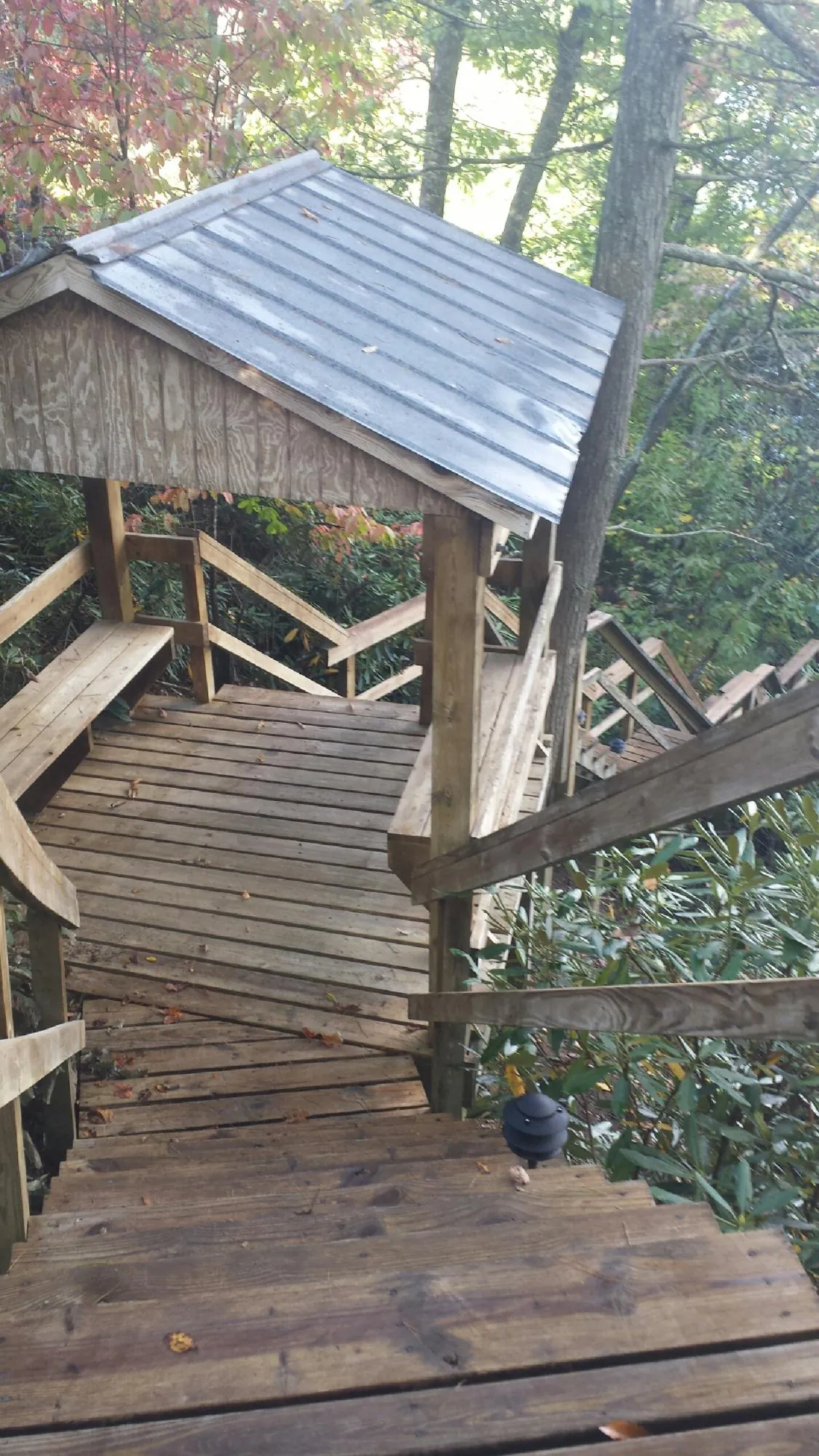 Metal roofed shelter over wooden steps on a wooded walkway — Skylight Repair & Installation work by our crew in Paterson