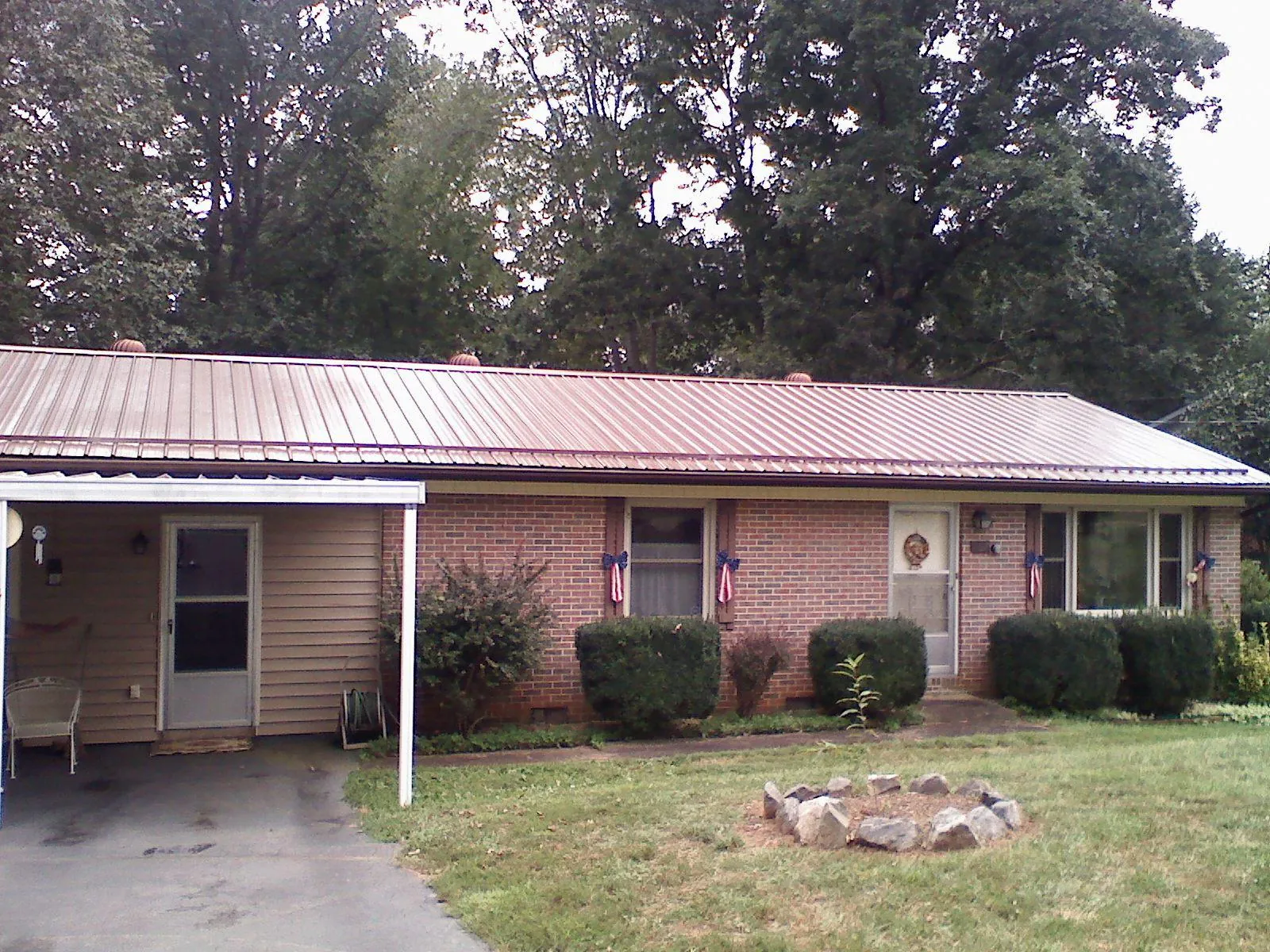 Bronze metal roof and carport on a brick ranch home — Roof Repair work by our crew in Paterson