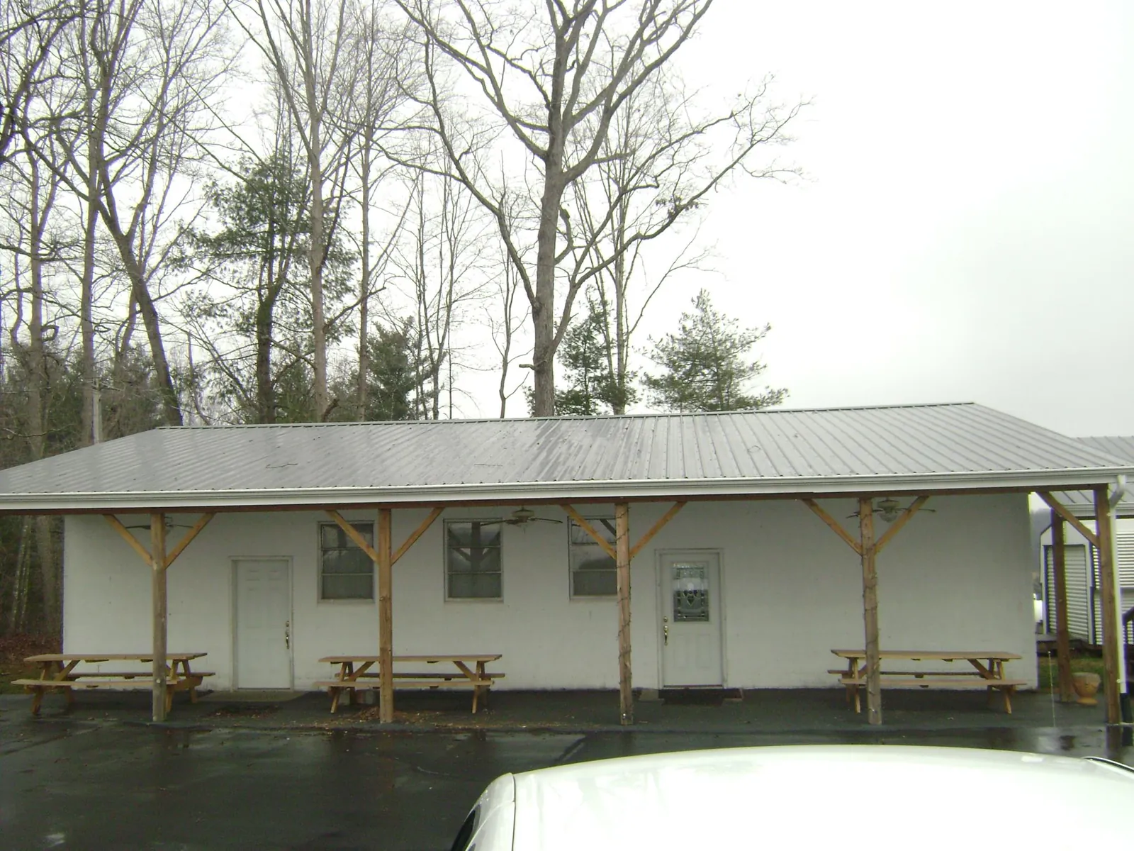 Gray metal roof over a block building with a timber post porch in Paterson
